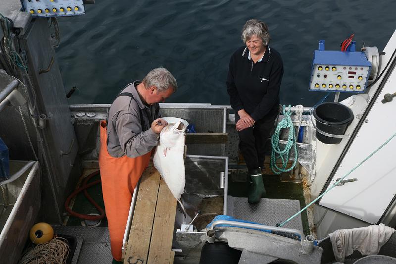 IMG_0789.JPG - Een visser toont ons de grootste vis die hij heeft gevangen vandaag. Hij was druk bezig ze schoon te maken en in moten te snijden. Grote platte vissen...